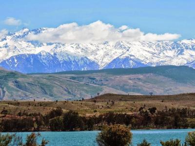 Turquoise waters of Lalla Takerkoust lake with the snow-capped High Atlas mountains behind