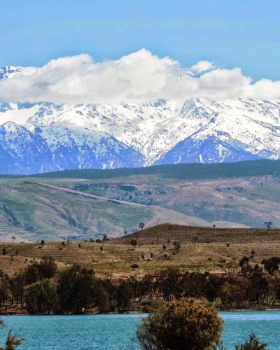 Turquoise waters of Lalla Takerkoust lake with the snow-capped High Atlas mountains behind
