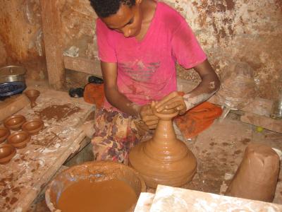 A potter shaping clay on the wheel in a workshop on the Colline des Potiers in Safi