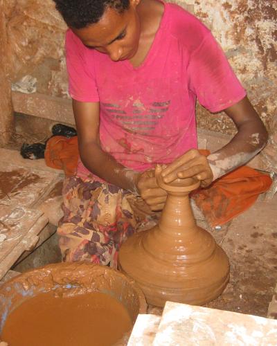 A potter shaping clay on the wheel in a workshop on the Colline des Potiers in Safi