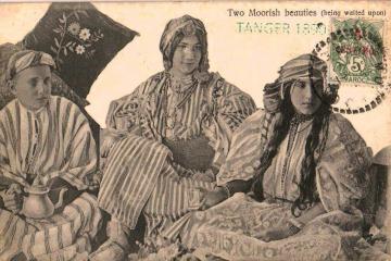 A vintage postcard showing three women in traditional Moroccan attire seated indoors, with the woman on the left holding a teapot.