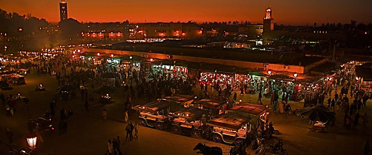 Jemaa el-Fna square in Marrakech at dusk, with the Koutoubia minaret